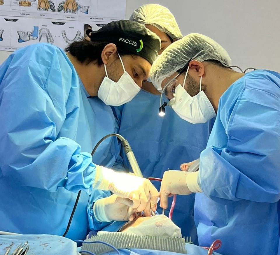 Equipe cirúrgica durante procedimento bucomaxilofacial